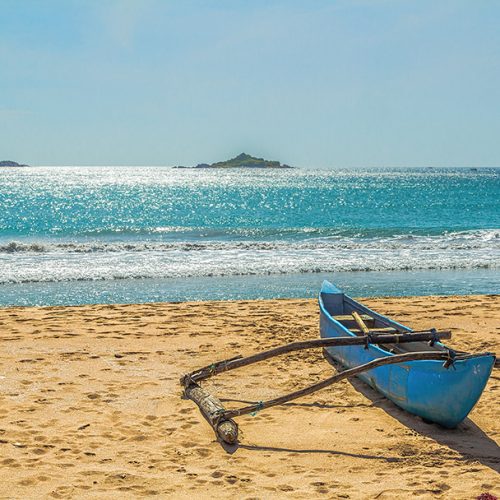 Aboriginal boat on the sandy shores of the Indian Ocean. Sri Lanka. The famous beach Nilaveli in the north-east